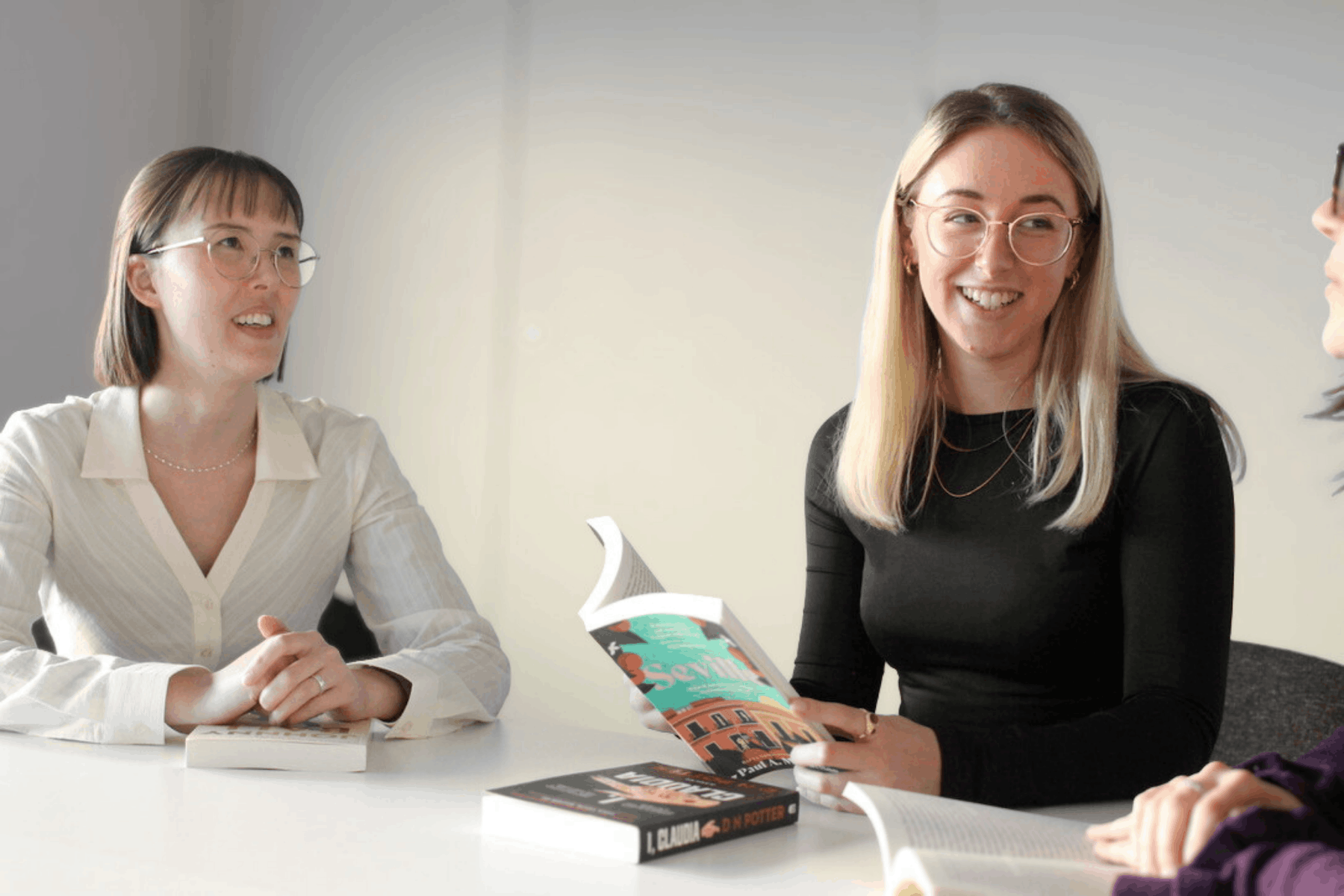 Two Libero team members discussing a book with an author