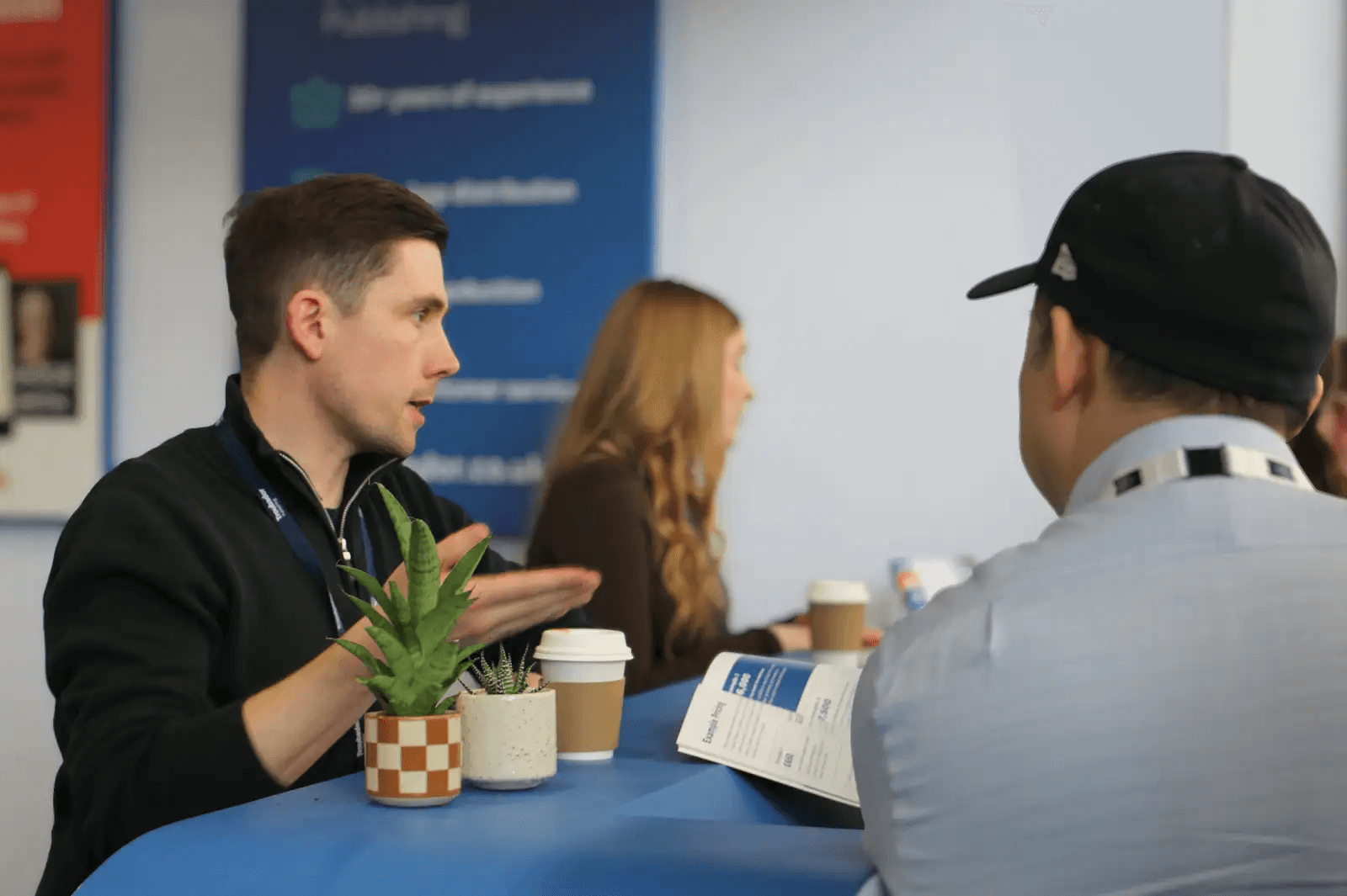 A Libero team member talking to authors at a publishing event